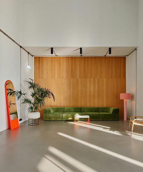 Modern fotostudio i Stockholm med grön soffa och träpanel.